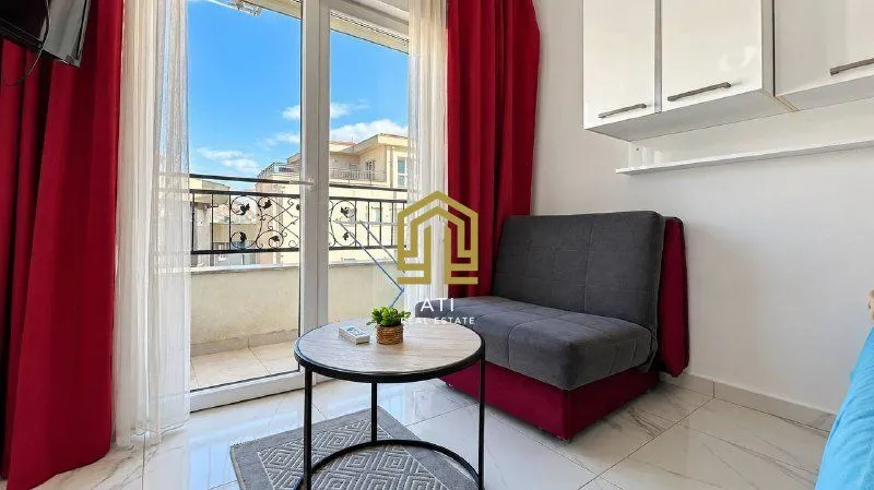 Smaller living room with a sofa, coffee table, and access to the terrace.
