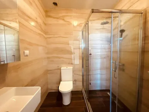 Kupatilo obloženo keramičkim pločicama sa tuš kabinom i WC šoljom. - image 14