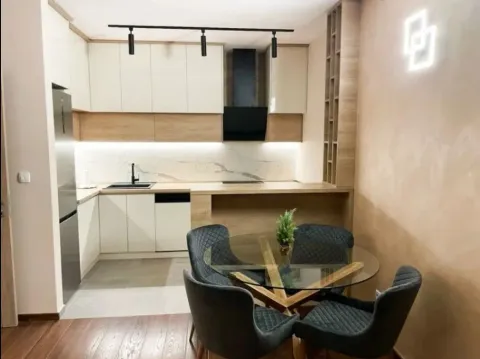 Modern kitchen with built-in cabinetry and a dining table with chairs. - image 9
