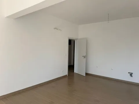Prazna soba sa bijelim zidovima i drvenim podom. - image 10