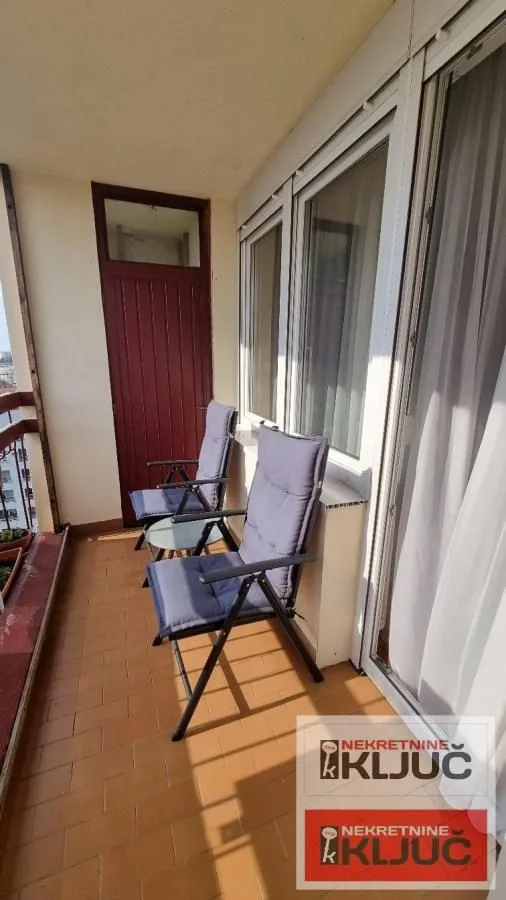 Nameštena terasa sa stolicama i stočićem.
