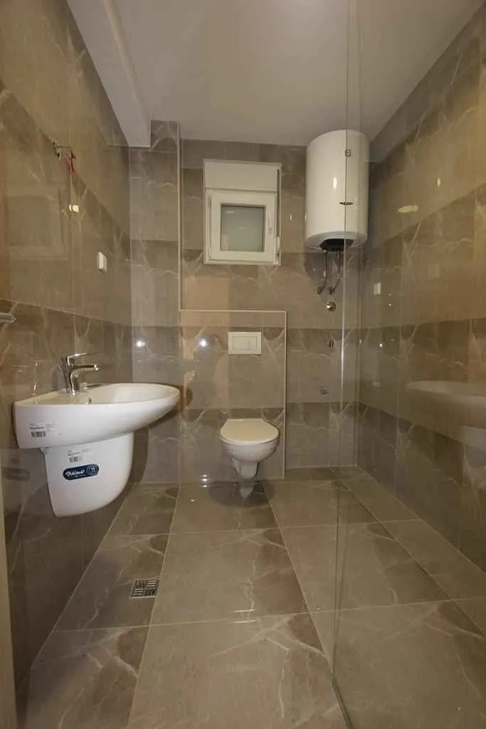 Novo kupatilo sa modernom keramikom i tuš kabinom.