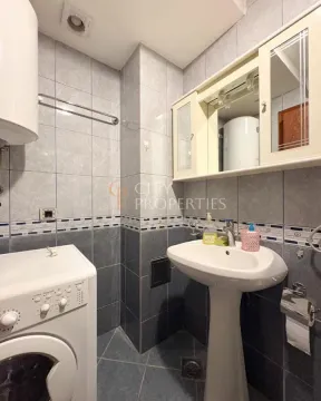 Kupatilo opremljeno umivaonikom, ormarićem sa ogledalom i veš mašinom. - image 11