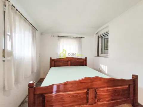 Bedroom with a large wooden bed and windows with white curtains. - image 17