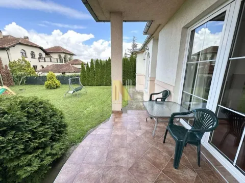Natkrivena terasa sa garniturom za sedenje i pogledom na travnato dvorište. - image 2