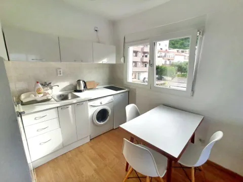Small white kitchen with a dining table and a window. - image 7