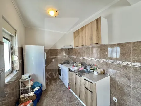 Smaller kitchen with wooden units, sink, and refrigerator. - image 3
