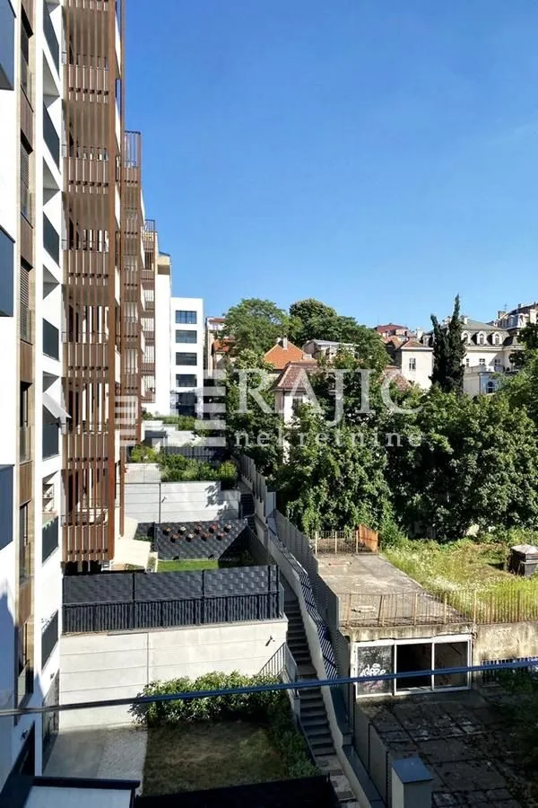 View from the terrace overlooking surrounding buildings and a green courtyard.