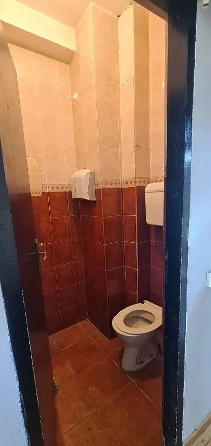 Small tiled bathroom with a toilet.