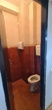 Small tiled bathroom with a toilet. - image 8