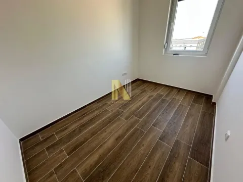 Prazna soba sa belim zidovima, podom u imitaciji drveta i jednim prozorom. - image 9