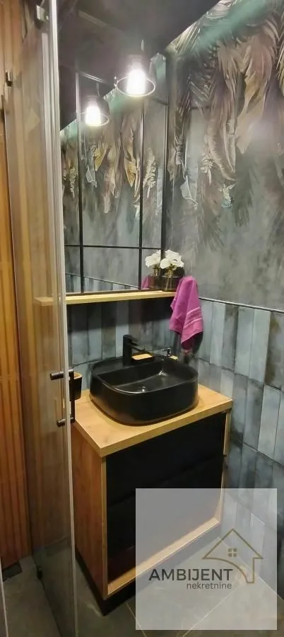 Modernly equipped bathroom with a washbasin and decorative tiles.