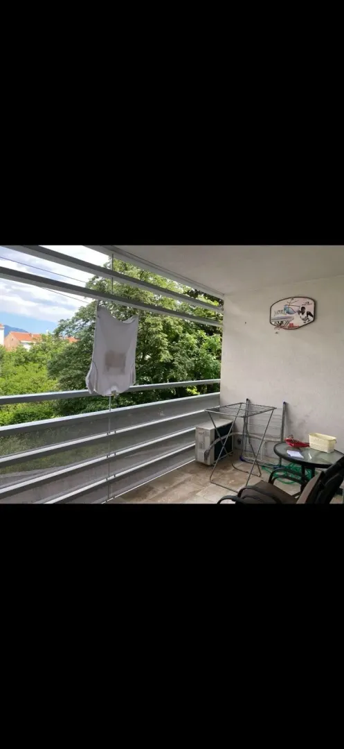 Unfurnished terrace with a clothes drying rack and a table.