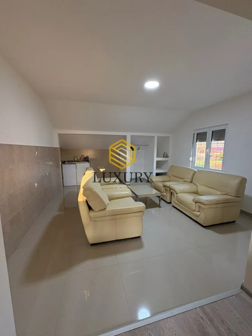 Spacious living room with seating furniture and a window view.
