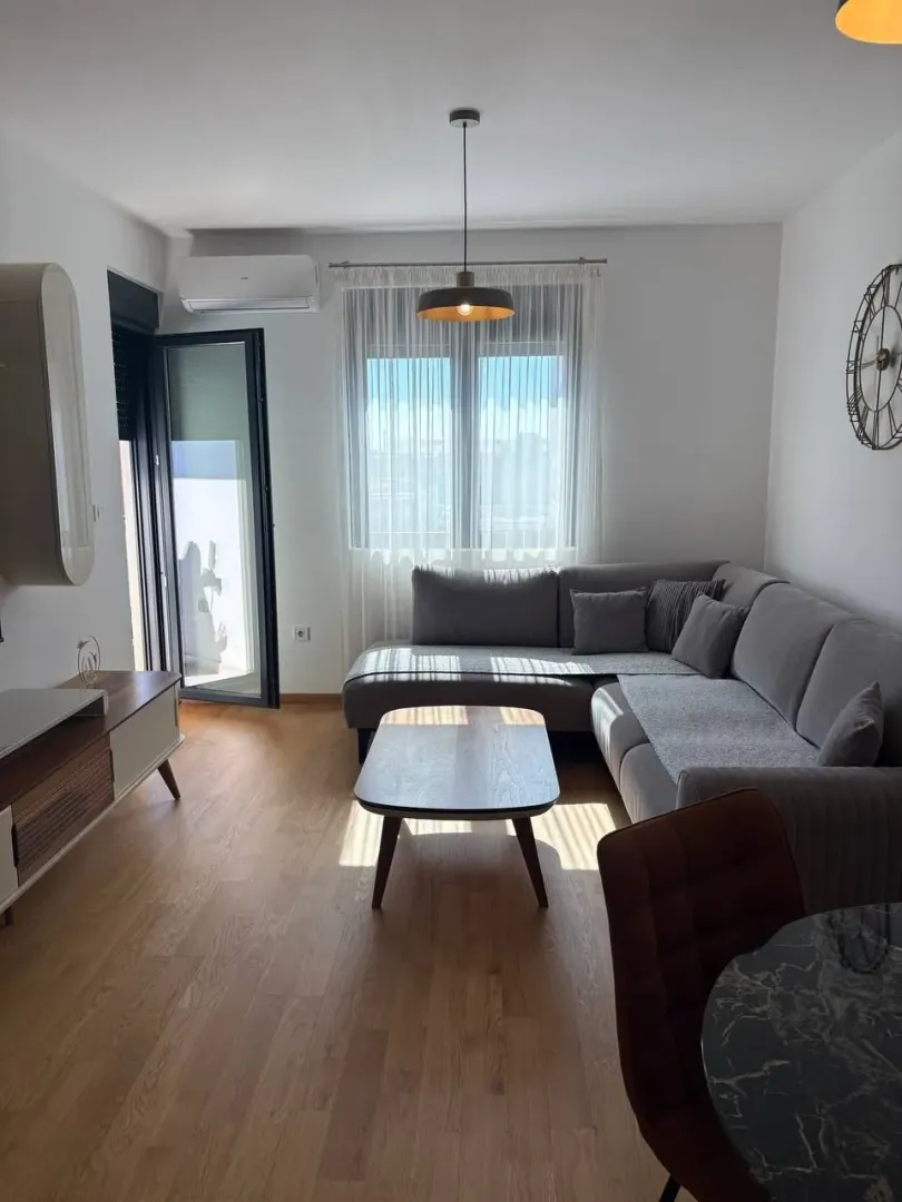 Dnevni boravak sa garniturom, stočićem i izlazom na terasu.