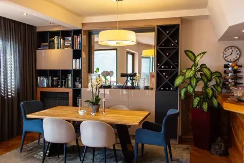 Bright dining area with a wooden table, modern chairs, and a bookshelf. - image 6