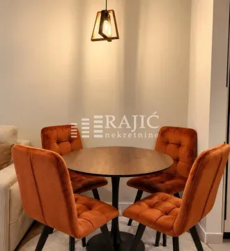 Trpezarijski kutak sa okruglim stolom i narandžastim stolicama. - image 6