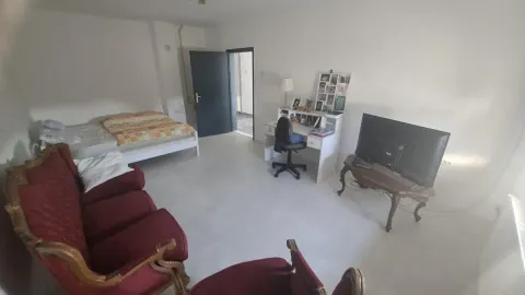 Prostrana dnevna soba sa garniturom, krevetom i televizorom. - image 10