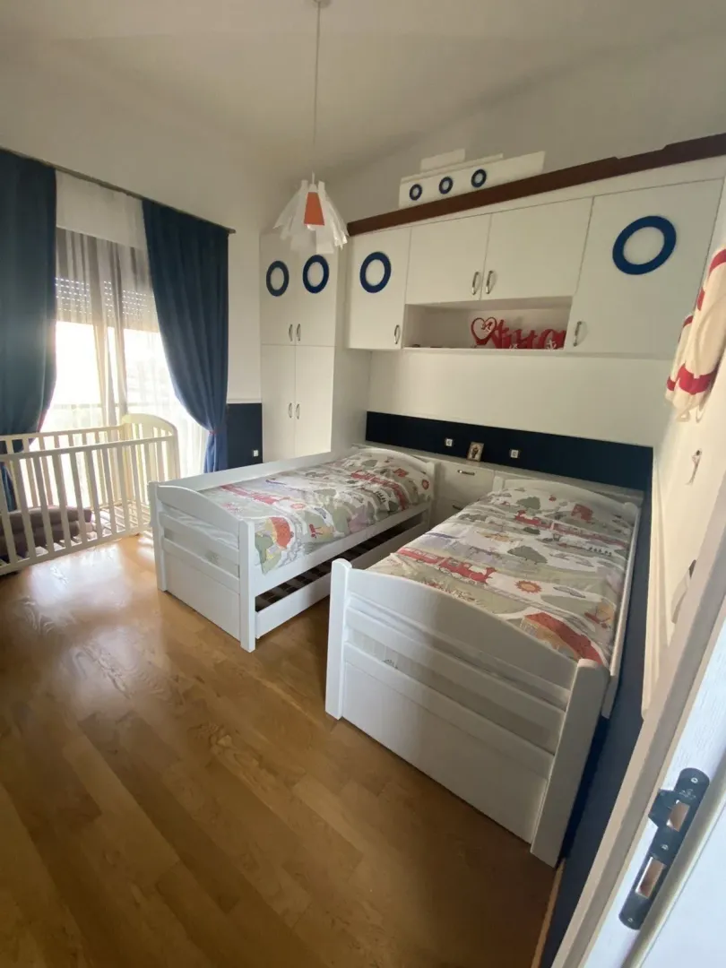 Children's bedroom with two beds and a crib.
