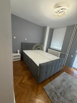 Spavaća soba sa bračnim krevetom, sivim zidovima i parketom. - image 10