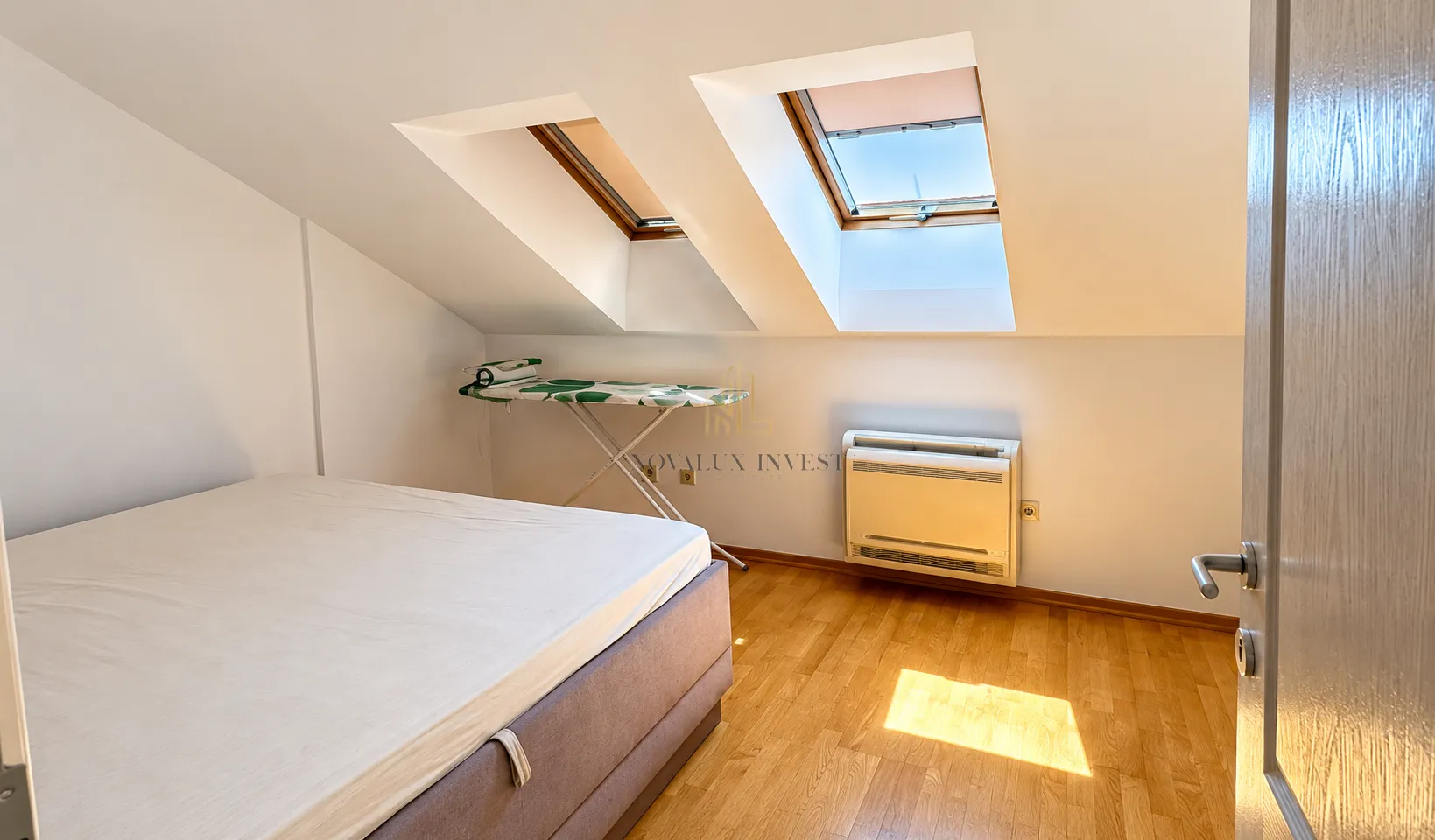 Attic bedroom with a double bed and skylights.