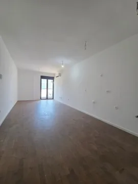 Prazna dnevna soba sa drvenim podom i balkonskim vratima. - image 3