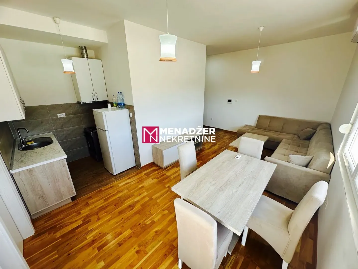 Living room with dining area and kitchen in bright tones.