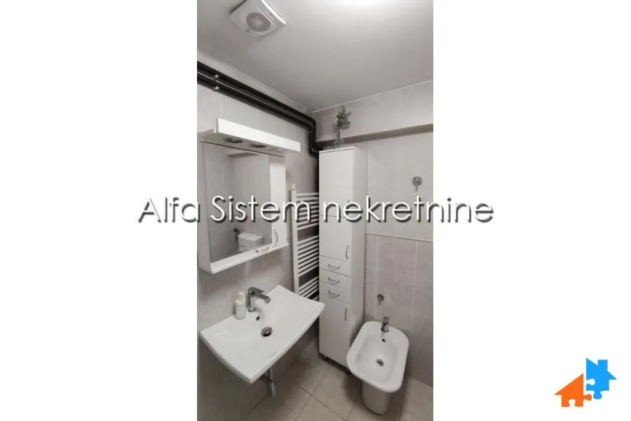 Compactly equipped bathroom with a washbasin, mirror and bidet.