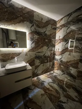 Modern bathroom with a walk-in shower and washbasin in marble tiles. - image 9