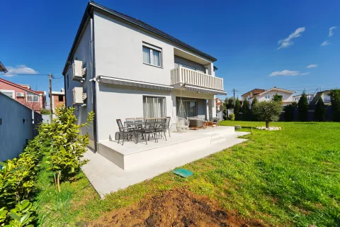 View of the rear side of the house with a terrace and landscaped yard. - image 11