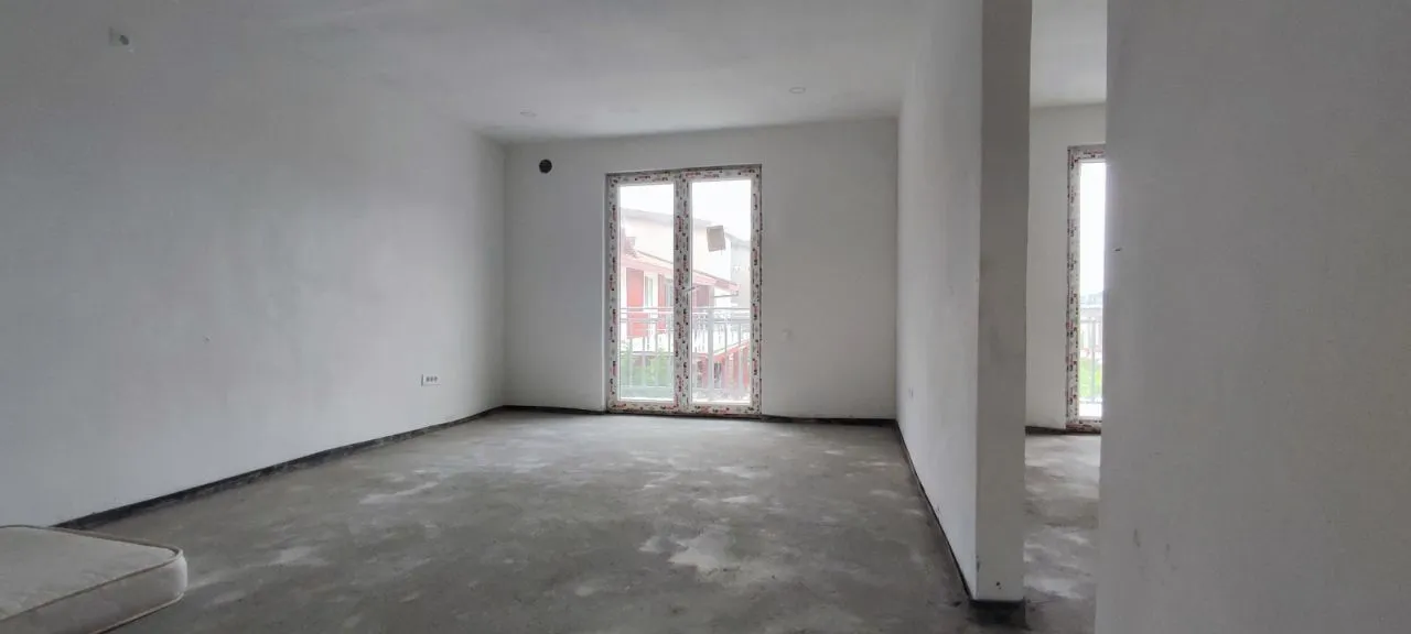 Empty room in rough construction phase with balcony doors.