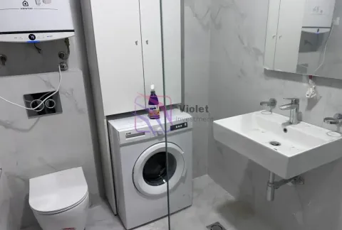 Modernly equipped bathroom with a washbasin, toilet, washing machine, and cabinet. - image 9