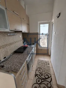Manja uska kuhinja sa drvenim elementima i izlazom na terasu. - image 3
