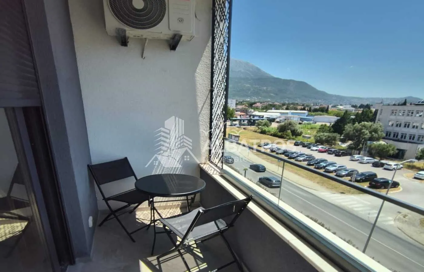 Manji namješteni balkon sa stolom i dvije stolice i pogledom na okolinu.