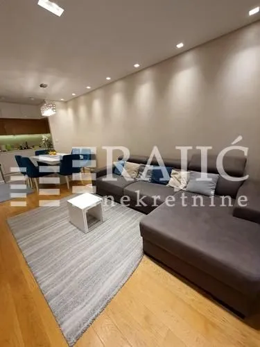 Living room with sofa and dining area in the background.