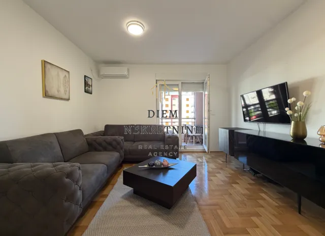 Living room with a sofa set, TV, and access to the terrace.