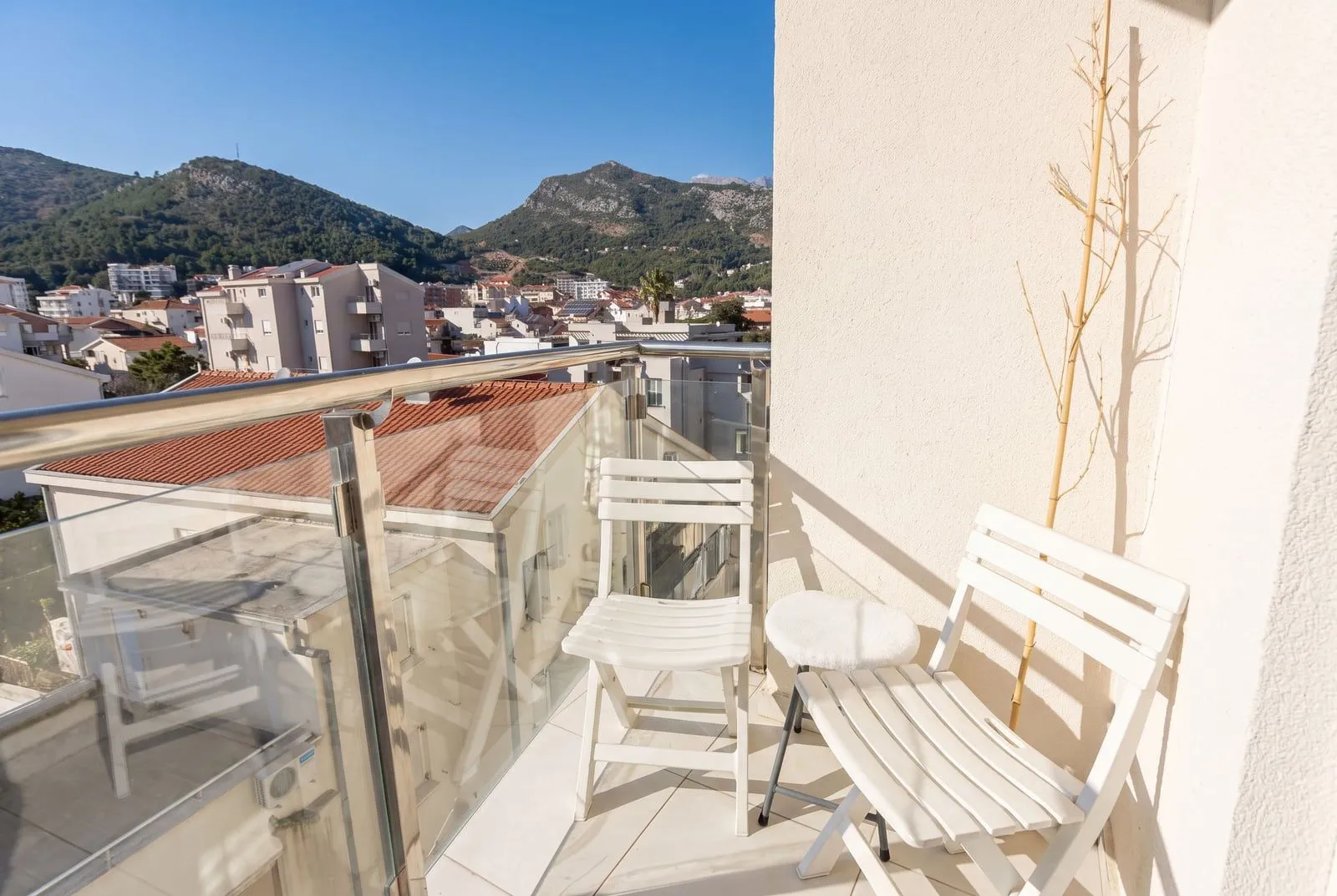 Furnished balcony with seating and a view of the city and mountains.