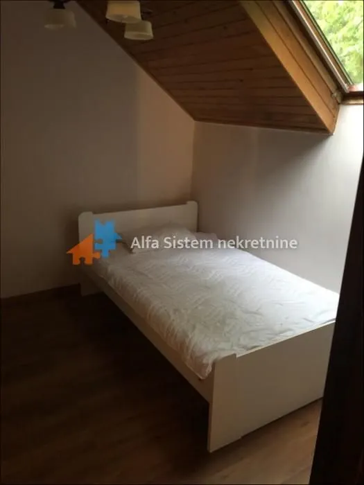Small bedroom with a bed and a roof window.