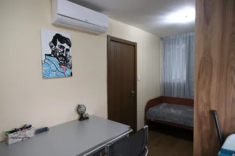 A simple bedroom featuring a desk and a single bed. - image 12