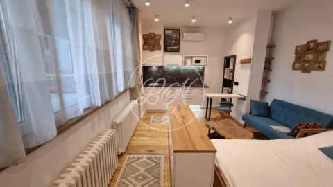 Pogled na dnevnu sobu sa sofom i kuhinjom u pozadini. - image 3