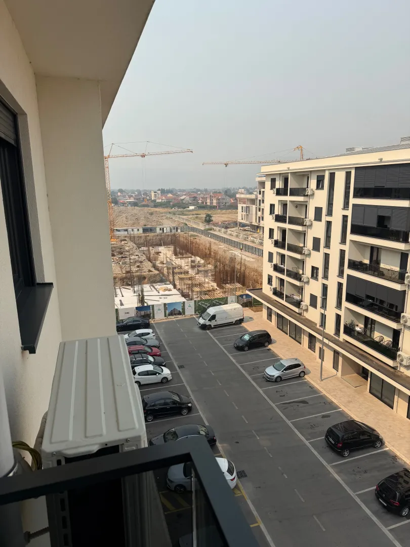 View from the balcony overlooking the parking lot and surrounding buildings under construction.