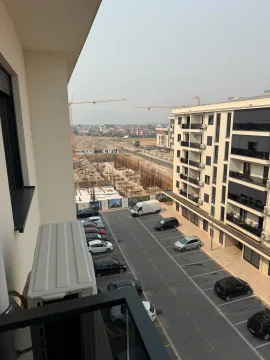 View from the balcony overlooking the parking lot and surrounding buildings under construction. - image 12