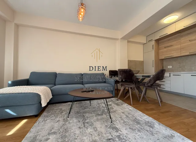 Living room with a sofa and a dining area combined with the kitchen.
