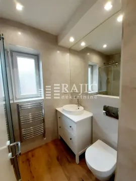 Modernly equipped bathroom with a washbasin and toilet. - image 10