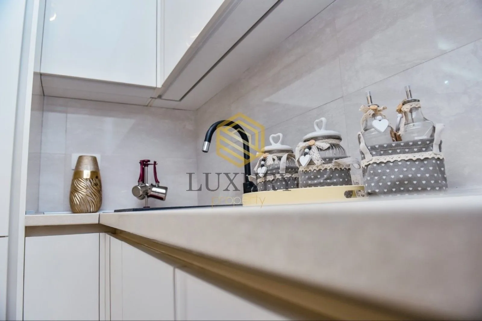 Modern kitchen with white cabinets and decorative details.