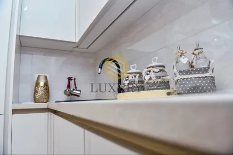 Modern kitchen with white cabinets and decorative details. - image 12