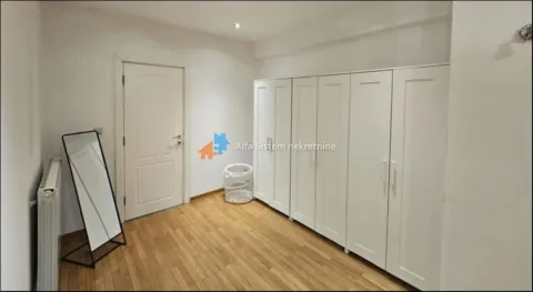 Bedroom with a large white wardrobe and wooden flooring. - image 7