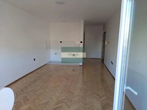 Prazna dnevna soba sa parketom i prostorom za kuhinju. - image 5