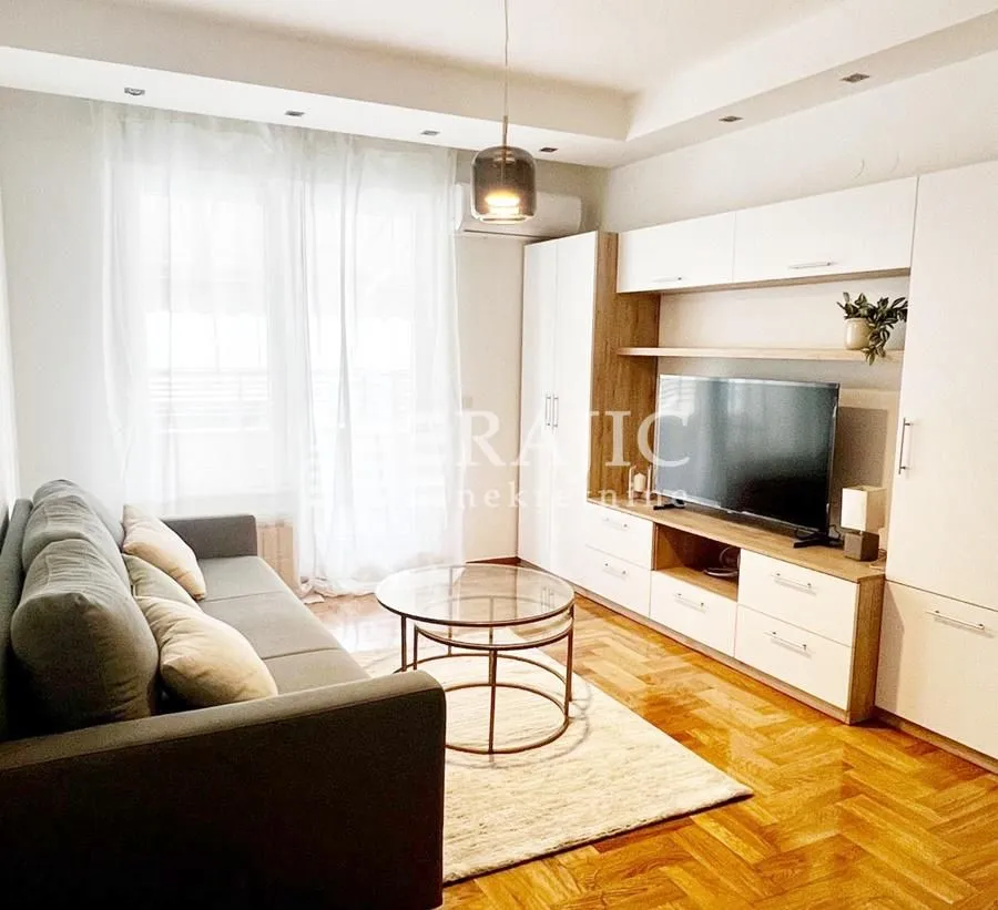Furnished living room with a sofa, TV unit, and coffee table.