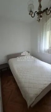 Smaller bedroom with a double bed and parquet flooring. - image 3